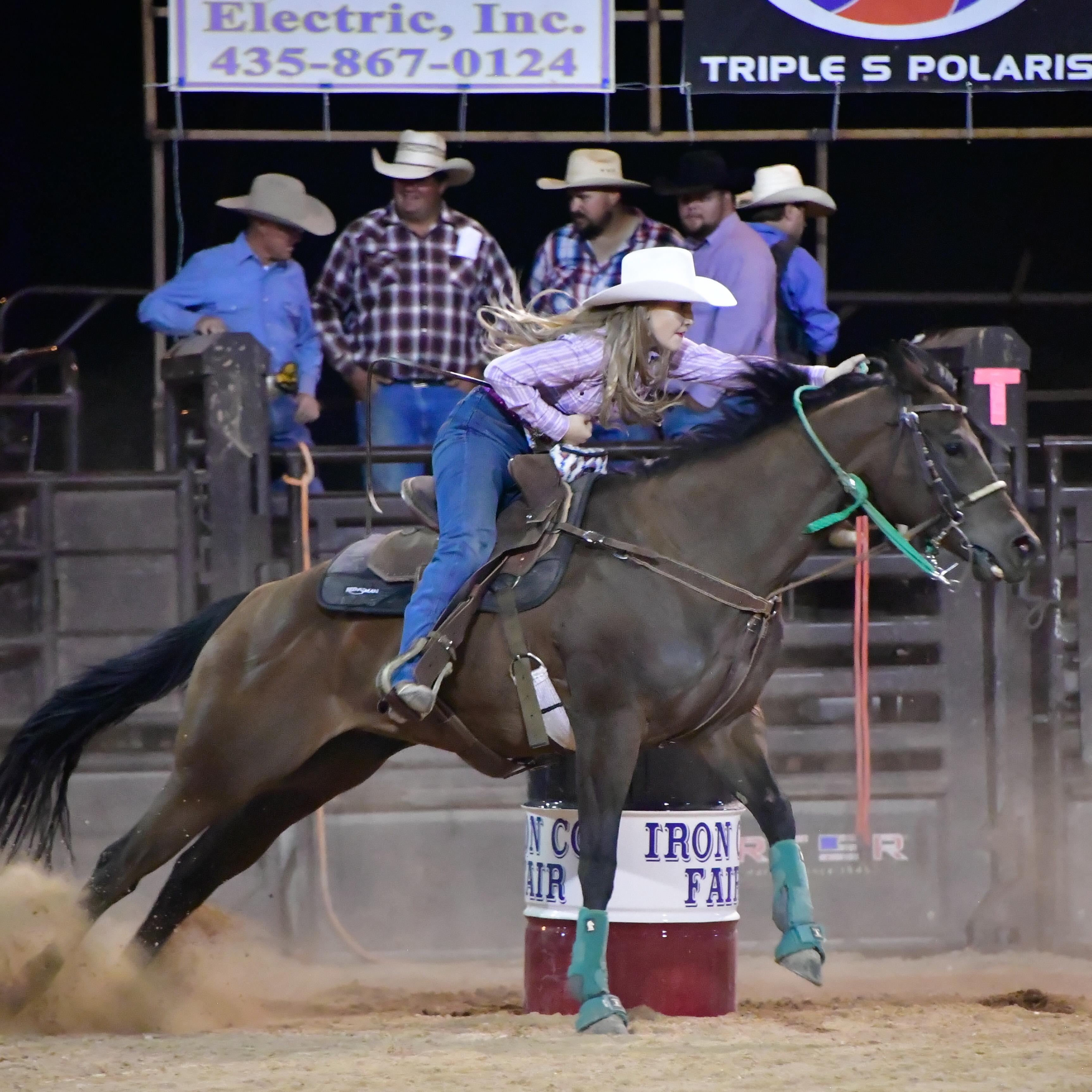 A horse and rider kicking up dust during a barrel race