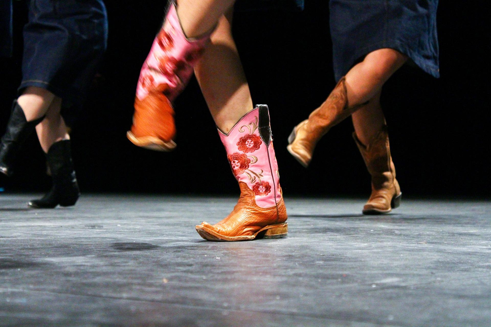 3 people with boots on dancing on a stage
