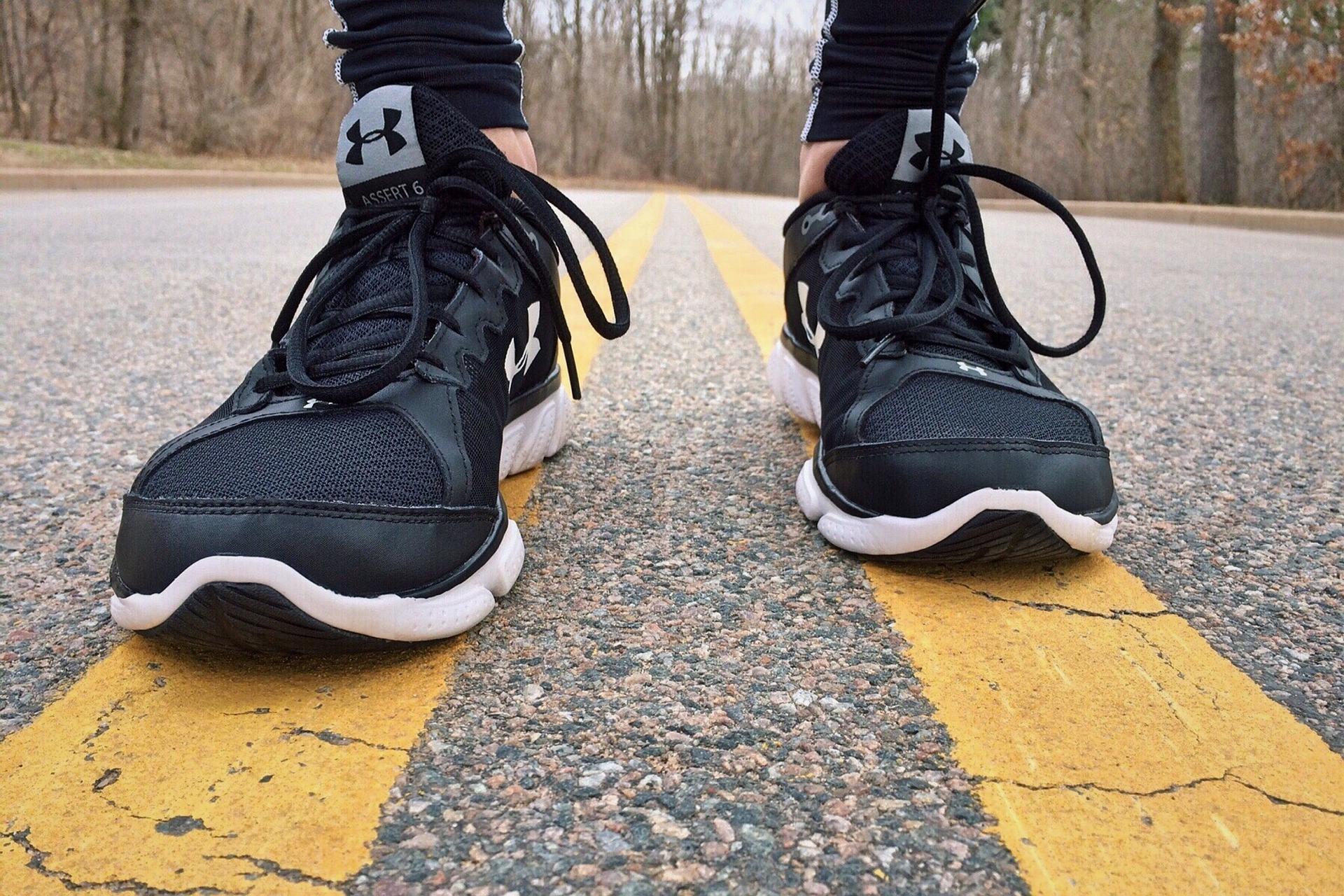 Image of a person wearing shoes on a road.