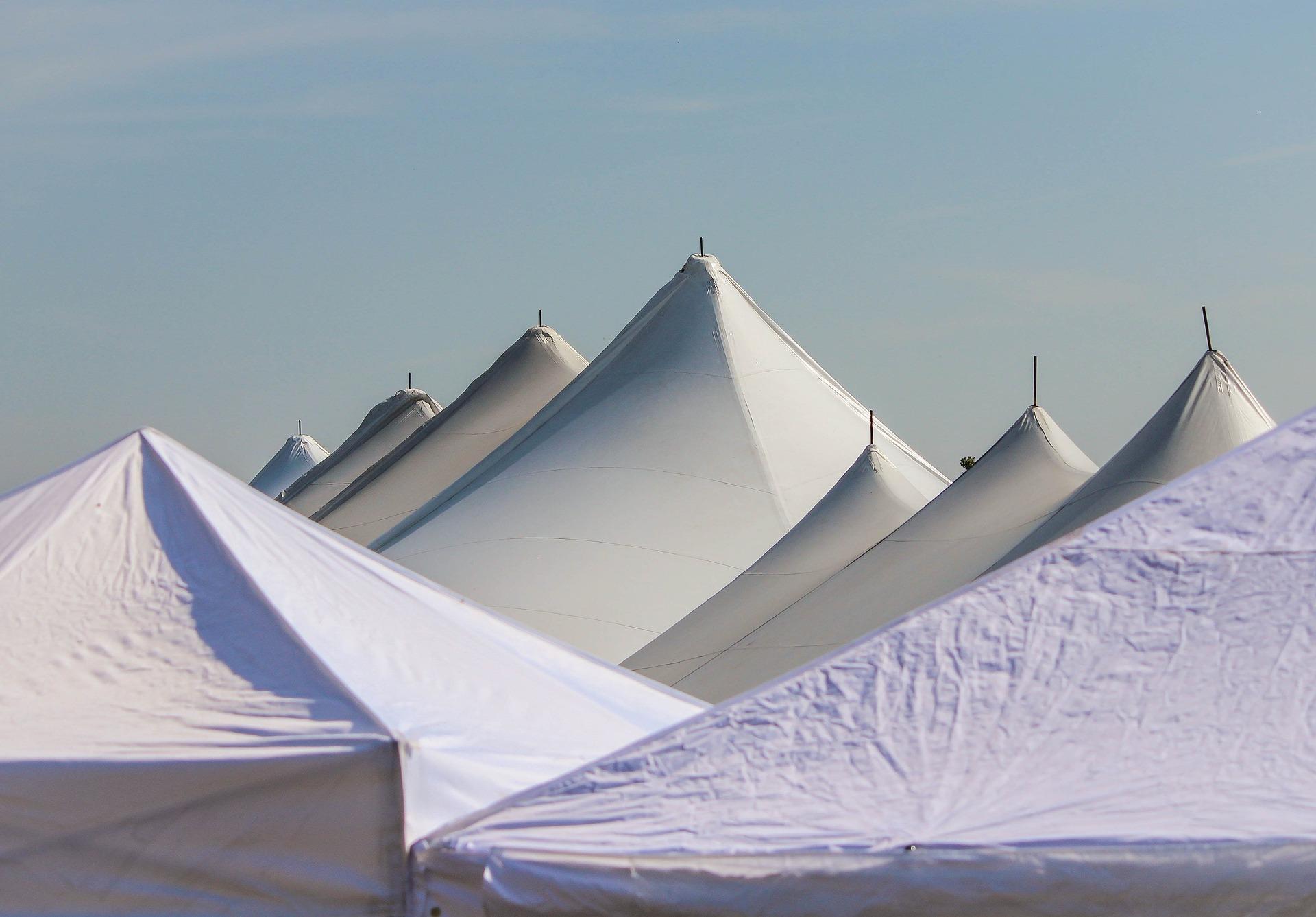 Giant white tents with the sky in the background.