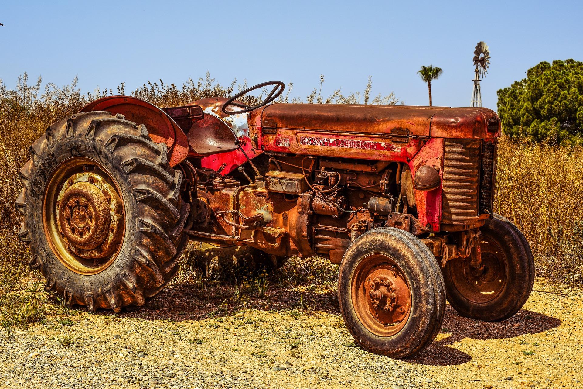 Old rusted tractor in a corn field